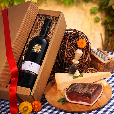 Un coffret cadeau avec du Merlot, du lard et du fromage à pâte dure.